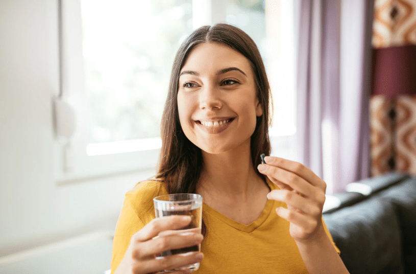 smiling woman taking supplements