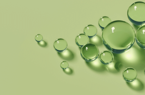 Abstract green background with clear orbs of varying sizes, symbolizing balance and renewal, representing peptide therapy at Formula Wellness.